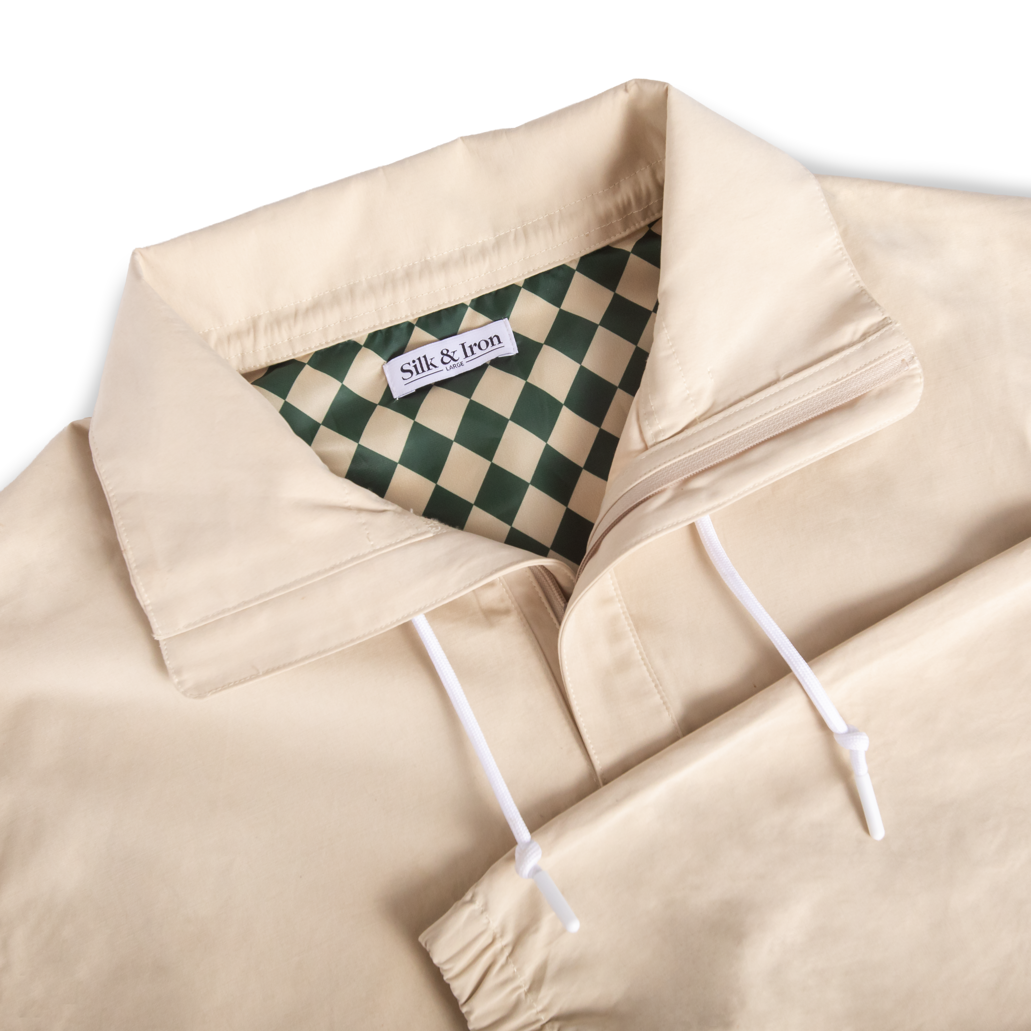 Beige jacket with white drawstrings and a green and white checkered lining, featuring the brand 'Silk & Iron'.